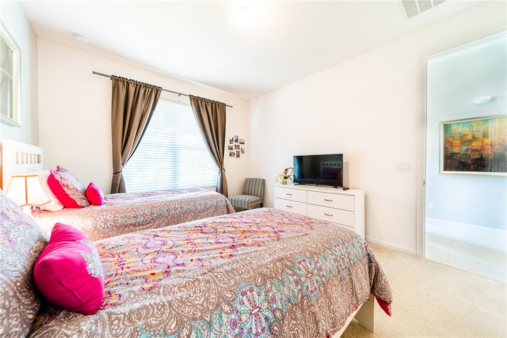 4027 Oakrise Loop Davenport, FL 33837 - Photo 34 of 66 a bedroom with a bed and a television