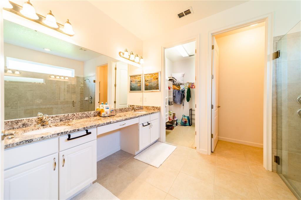 4027 Oakrise Loop Davenport, FL 33837 - Photo 35 of 66 a large bathroom with a granite countertop sink mirror and a