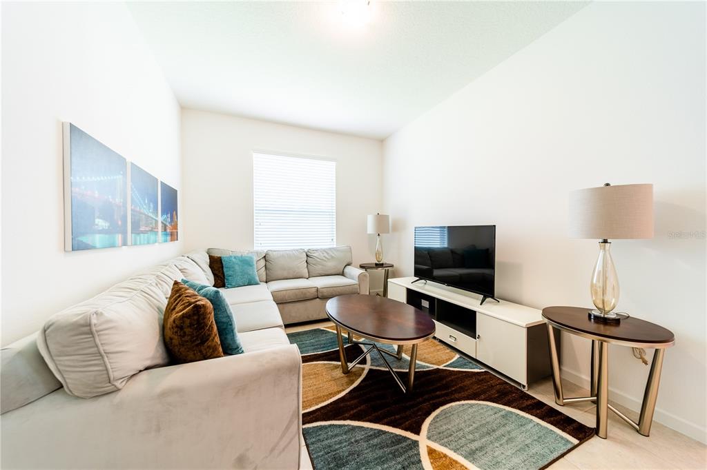 4027 Oakrise Loop Davenport, FL 33837 - Photo 40 of 66 a living room with furniture a flat screen tv and a window