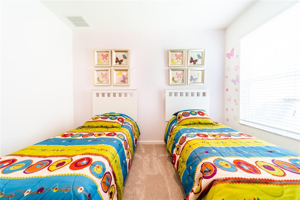 4027 Oakrise Loop Davenport, FL 33837 - Photo 43 of 66 a bedroom with two beds and a painting on the wall