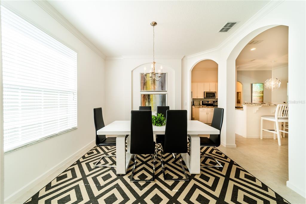4027 Oakrise Loop Davenport, FL 33837 - Photo 7 of 66 a view of a dining room with furniture window and wooden floor