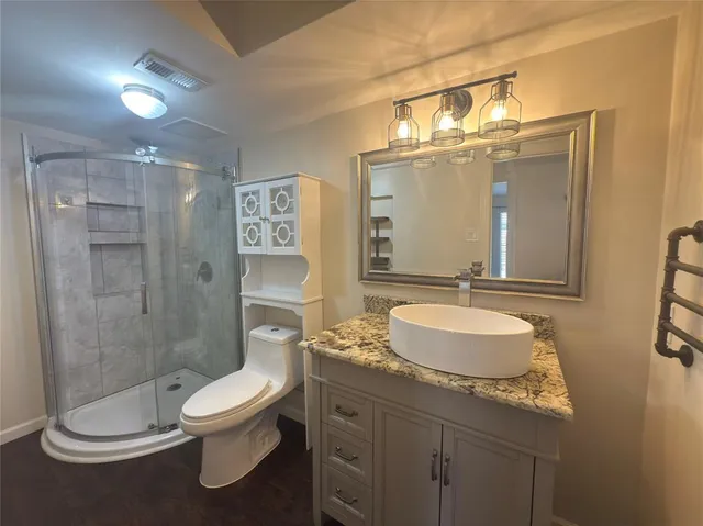 a bathroom with a granite countertop sink toilet and shower