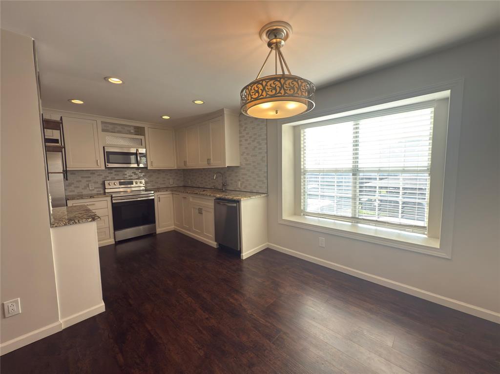 12480 Abrams Road, Unit 2922 Dallas, TX 75243 - Photo 8 of 25 a kitchen with stainless steel appliances granite countertop a stove a refrigerator and a wooden floor
