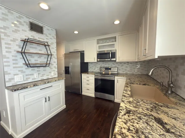 a kitchen with stainless steel appliances granite countertop a refrigerator sink and stove