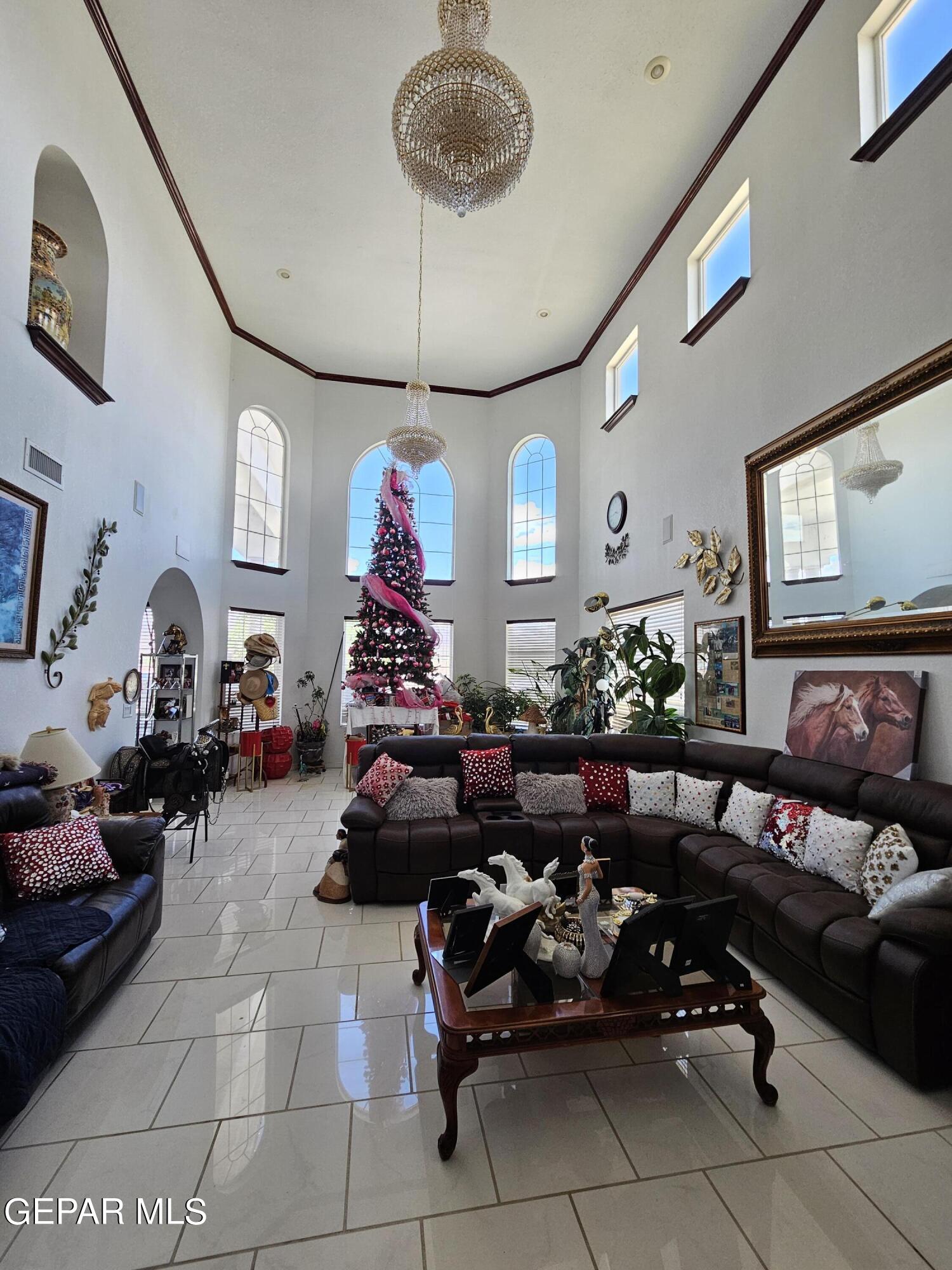 6651 Strahan Road El Paso, TX 79932 - Photo 37 of 60 a living room with furniture gym equipment and a chandelier