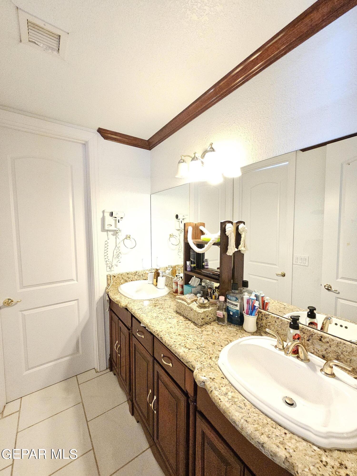 6651 Strahan Road El Paso, TX 79932 - Photo 47 of 60 a bathroom with a granite countertop sink and a mirror