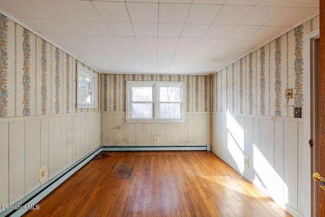 a view of empty room with wooden floor
