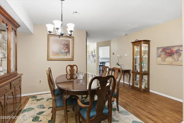 a view of a dining room with furniture wooden floor and a chandelier