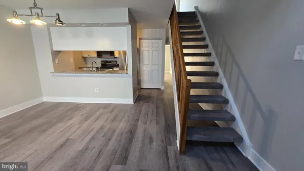 a view of a hallway with wooden floor and entryway