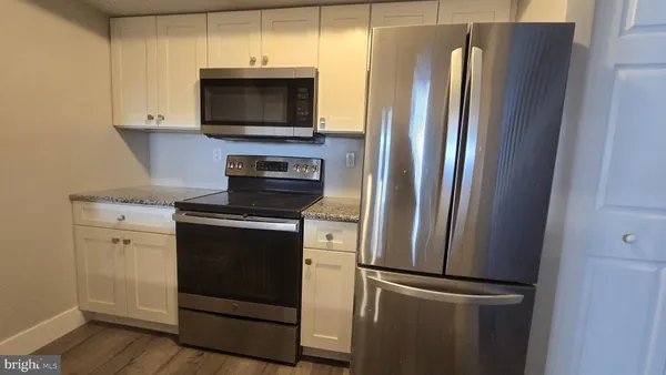 a kitchen with stainless steel appliances a refrigerator microwave and stove top oven