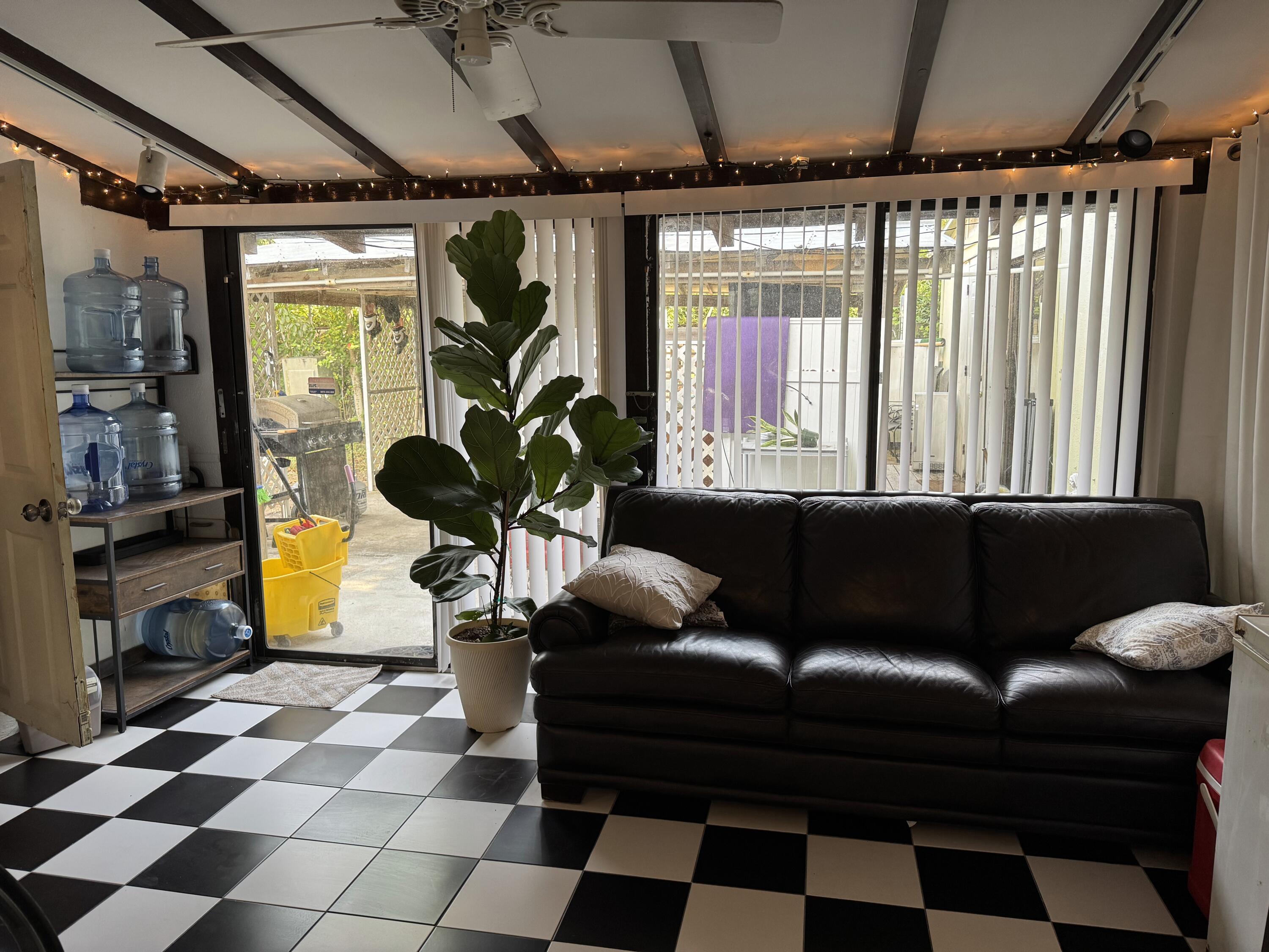 1610 Laird Street Key West, FL 33040 - Photo 3 of 22 a living room with a black white checkered floor with a gaming machine and dining table