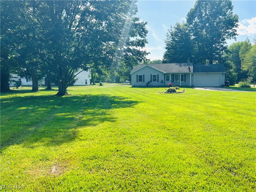 5636 Laskey Road Rome, OH 44085 - Photo 2 of 29 View of green lawn featuring a garage and driveway