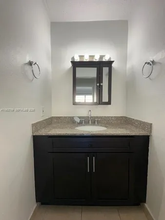 a bathroom with a sink vanity and mirror