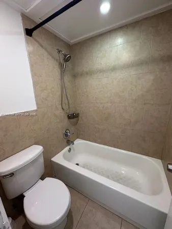 a white bath tub sitting next to a white toilet and sink