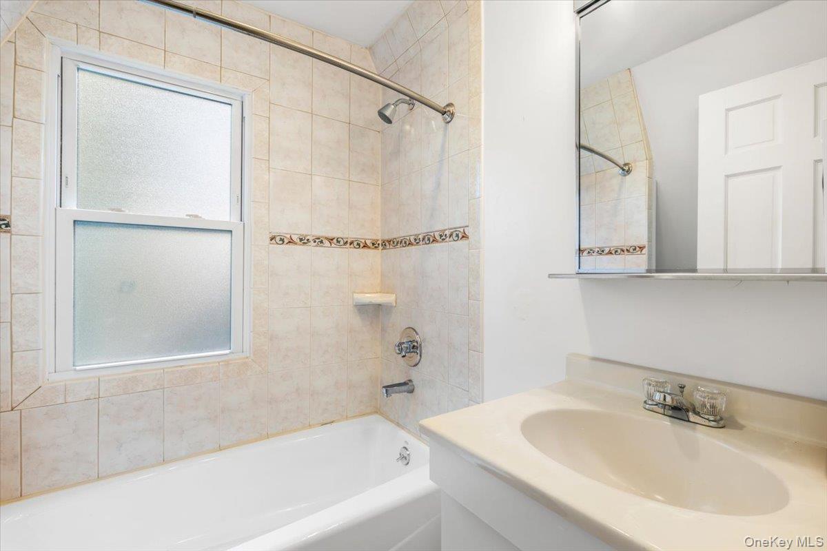 620 Timpson Street Pelham, NY 10803 - Photo 21 of 32 a white bath tub sitting next to a white sink and a shower