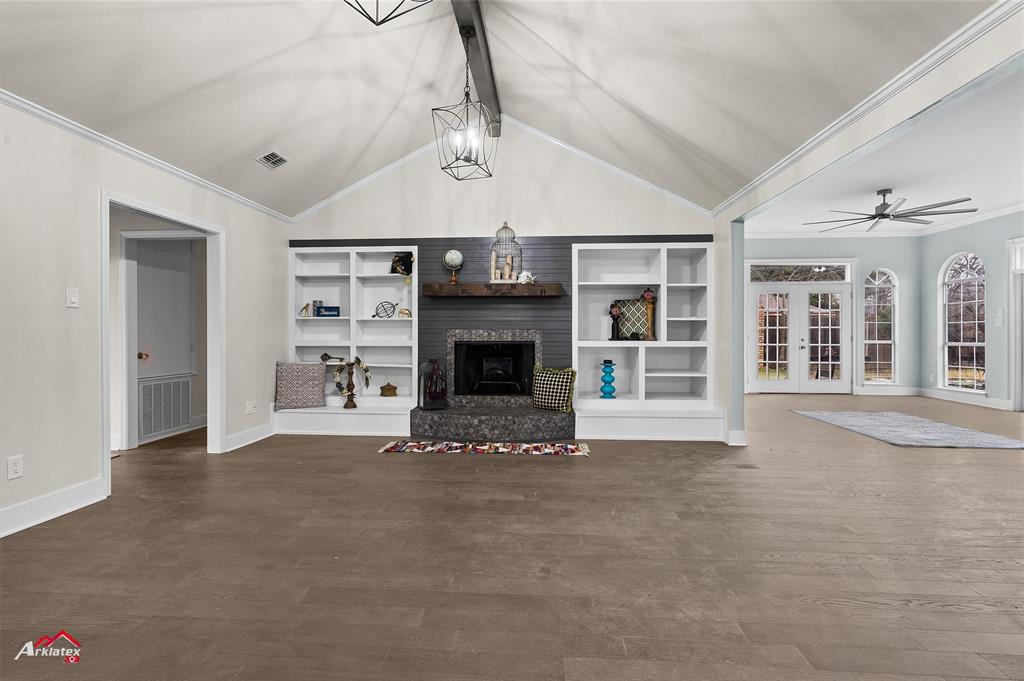 a view of an empty room with a fireplace and a window