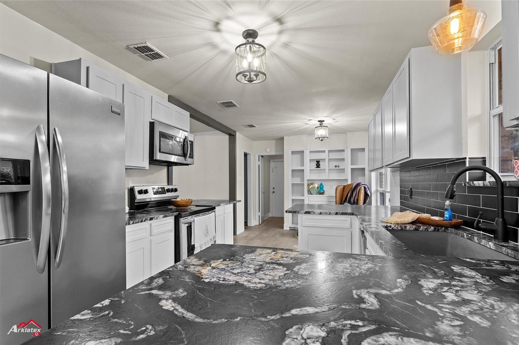 5524 Hickory Ridge Drive Bossier City, LA 71111 - Photo 3 of 17 a kitchen with stainless steel appliances kitchen island granite countertop a refrigerator a stove a sink a dining table and chairs with wooden floor