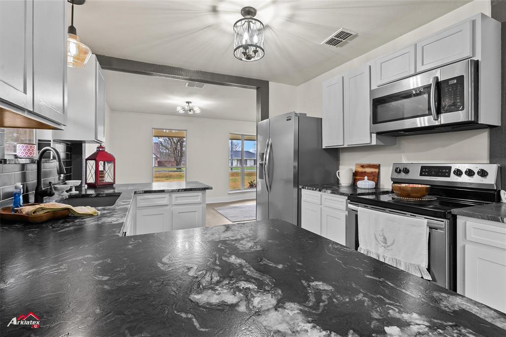 5524 Hickory Ridge Drive Bossier City, LA 71111 - Photo 5 of 17 a kitchen with stainless steel appliances granite countertop a sink dishwasher stove and refrigerator with wooden floor