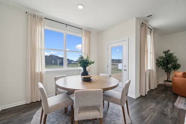 a dining room with furniture window and wooden floor