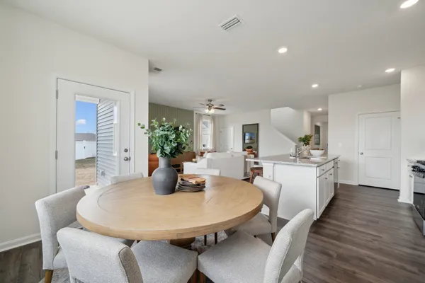 a kitchen with sink dining table and chairs