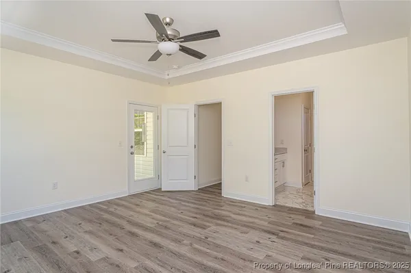 a view of a livingroom with wooden floor and a ceiling fan