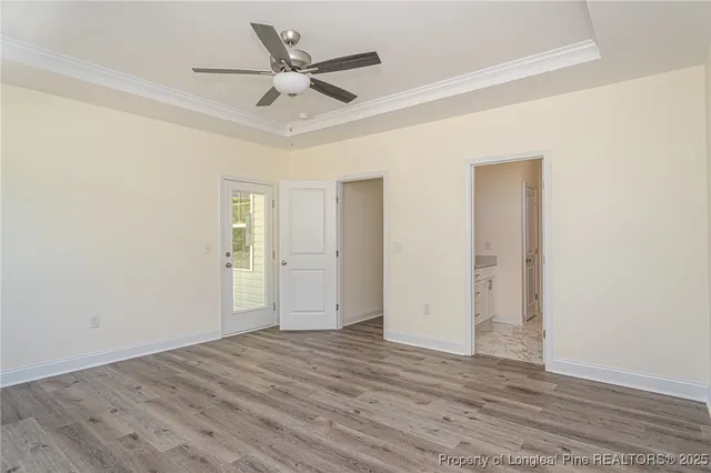 a view of a livingroom with wooden floor and a ceiling fan