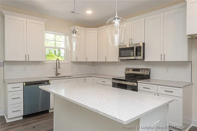 a kitchen with stainless steel appliances a stove a sink a microwave and cabinets