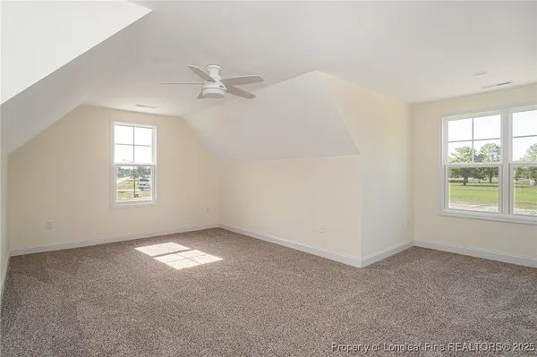 an empty room with windows and ceiling fan view