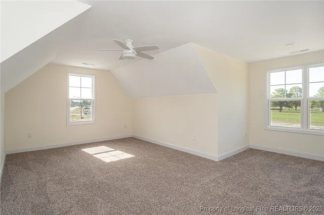 an empty room with windows and ceiling fan view