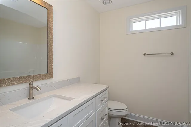 a bathroom with a sink toilet and a mirror