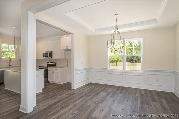 a kitchen with a refrigerator and white cabinets