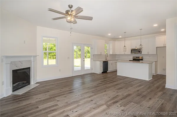 a view of a kitchen with a stove cabinets wooden floor and a ceiling fan