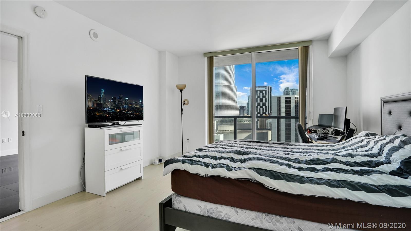 55 Southeast 6th Street, Unit 1903 Miami, FL 33131 - Photo 12 of 26 a bedroom with a bed and a view of living room