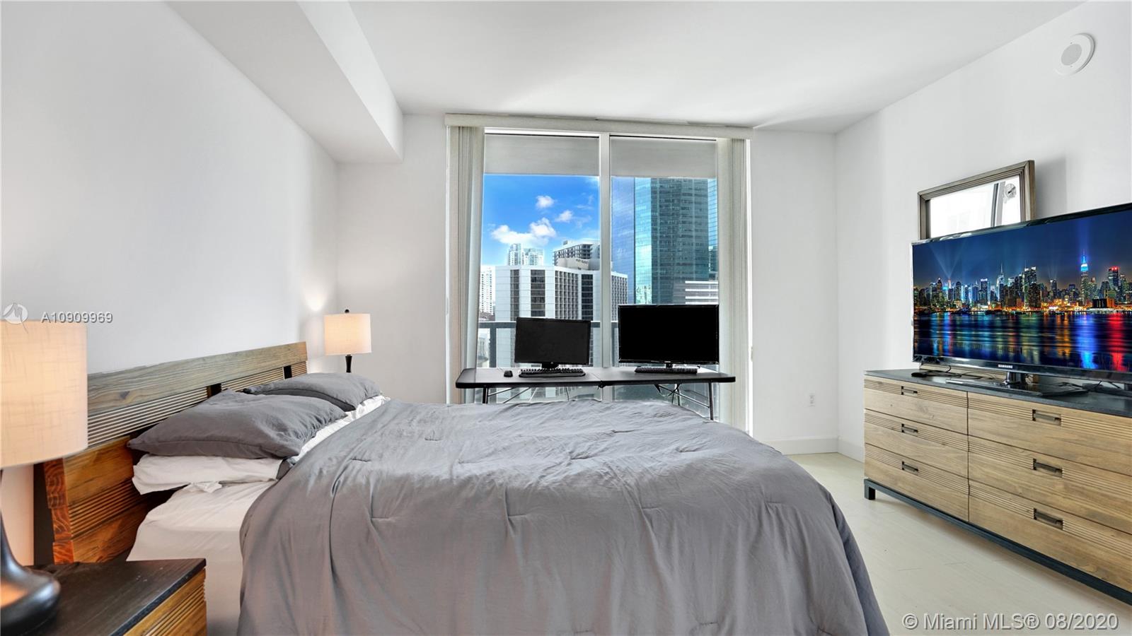 55 Southeast 6th Street, Unit 1903 Miami, FL 33131 - Photo 14 of 26 a bedroom with a bed and a television