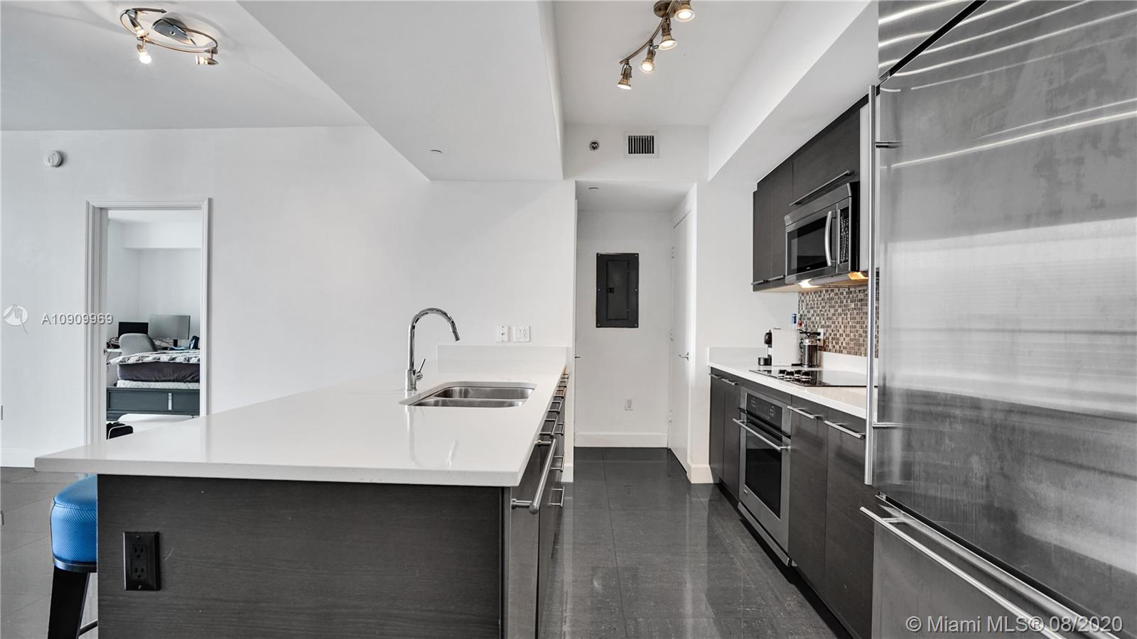 55 Southeast 6th Street, Unit 1903 Miami, FL 33131 - Photo 3 of 26 a kitchen with stainless steel appliances granite countertop a sink and stove top oven