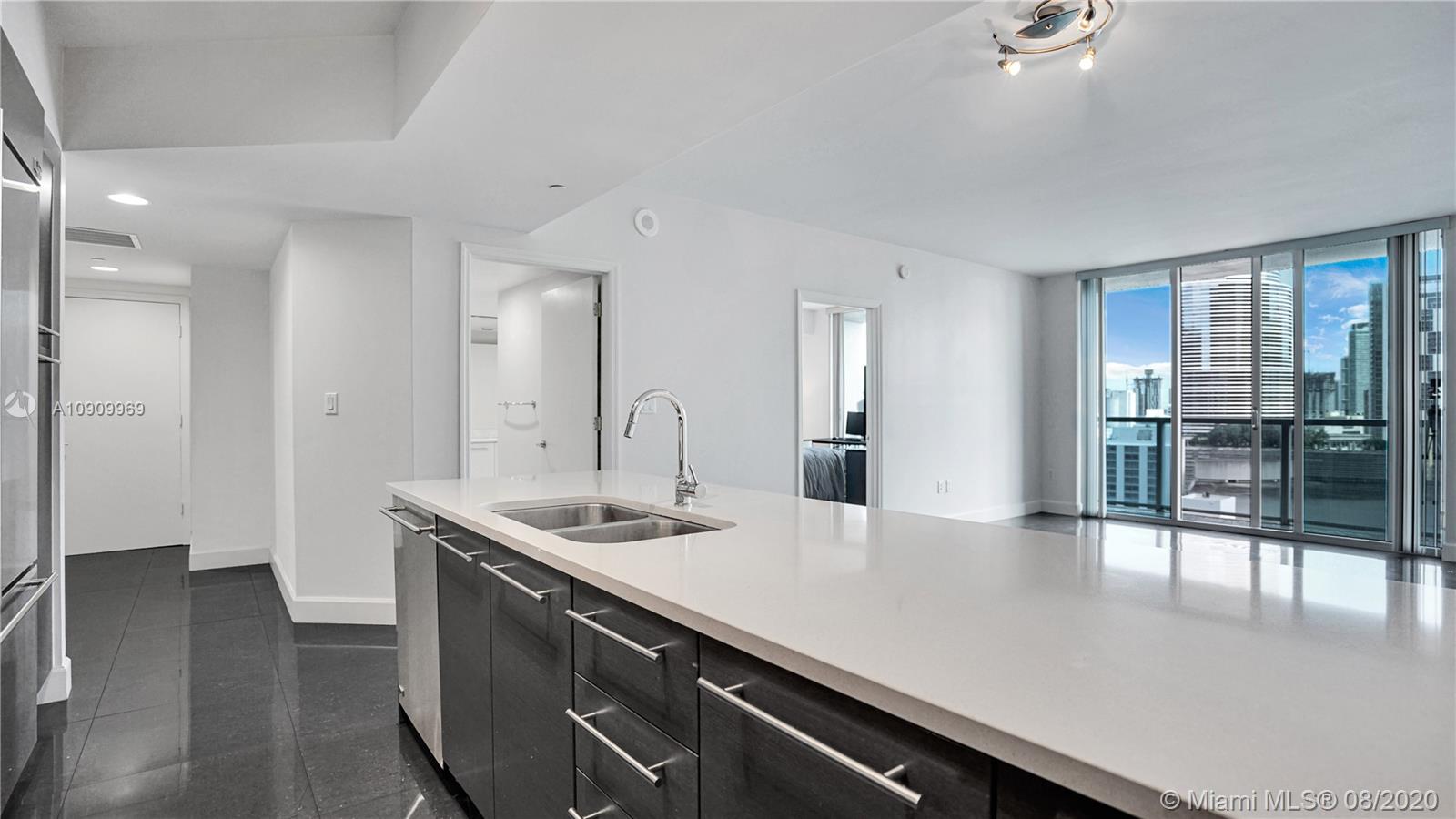 55 Southeast 6th Street, Unit 1903 Miami, FL 33131 - Photo 7 of 26 a kitchen with kitchen island a sink appliances and cabinets