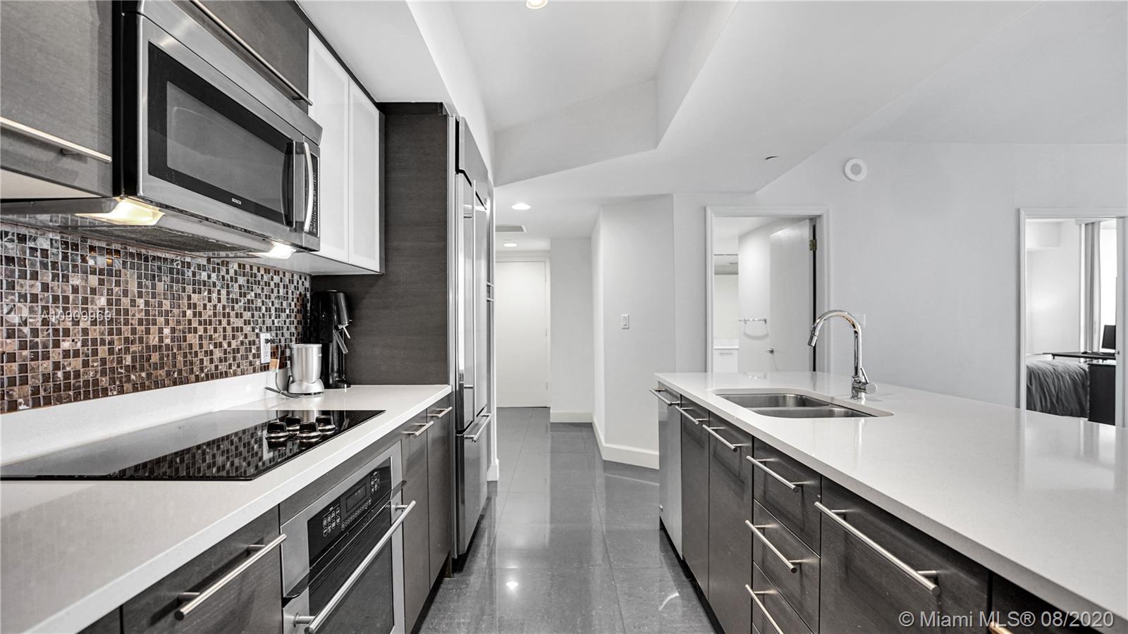 55 Southeast 6th Street, Unit 1903 Miami, FL 33131 - Photo 9 of 26 a kitchen with stainless steel appliances a sink stove and refrigerator