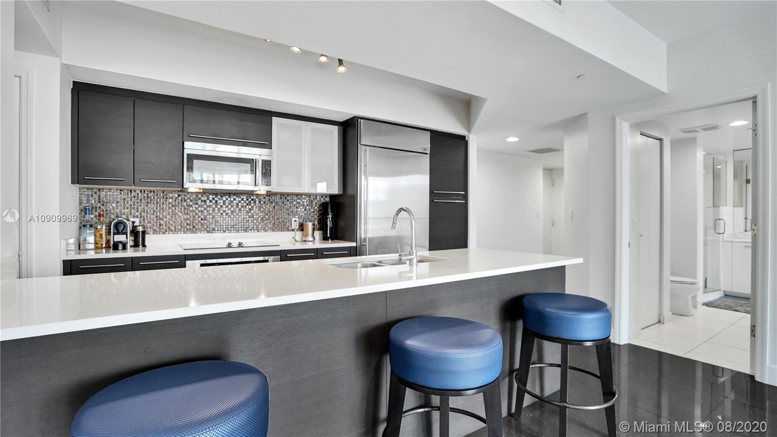 55 Southeast 6th Street, Unit 1903 Miami, FL 33131 - Photo 10 of 26 a kitchen with stainless steel appliances a sink and a refrigerator