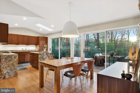a dining hall with stainless steel appliances kitchen island granite countertop a dining table and chairs