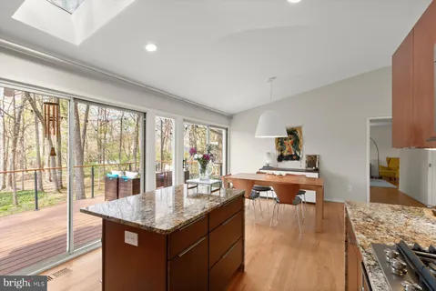 a living room with kitchen island furniture a flat screen tv and a large window