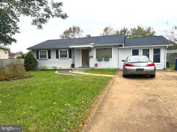 a front view of a house with a garden and trees