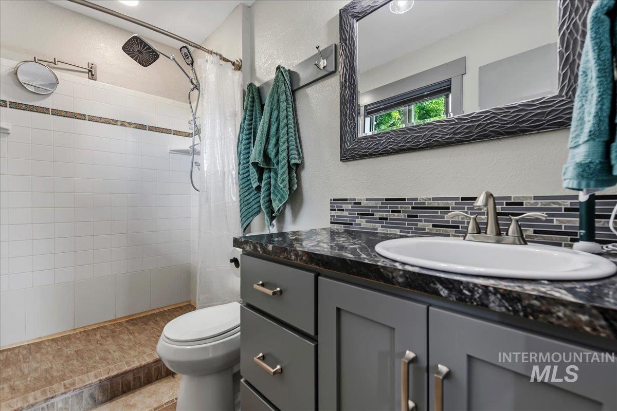 6323 Foothill Road Star, ID 83669 - Photo 25 of 50 Bathroom featuring a grey vanity with a dark countertop, white oval undermount sink, and brushed nickel faucet
