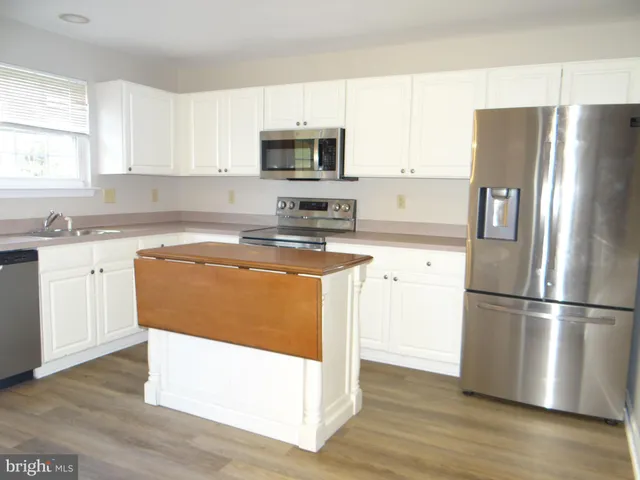 a kitchen with wooden cabinets and stainless steel appliances