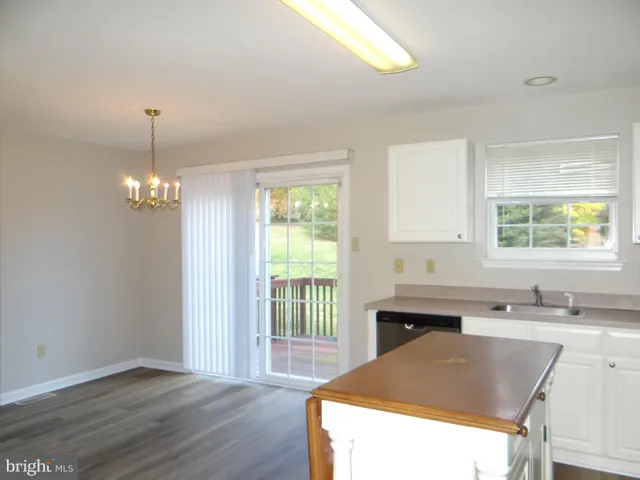 a kitchen with granite countertop a sink stainless steel appliances and window