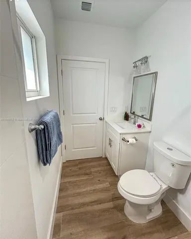 a bathroom with a toilet a sink and mirror