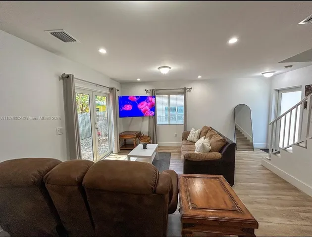 a living room with furniture and a wooden floor