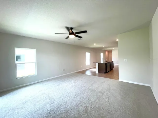 a view of empty room with a ceiling fan and window