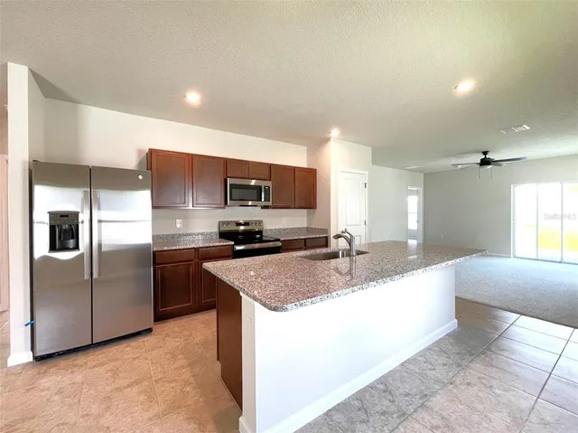 a kitchen with stainless steel appliances granite countertop a sink a stove and a refrigerator