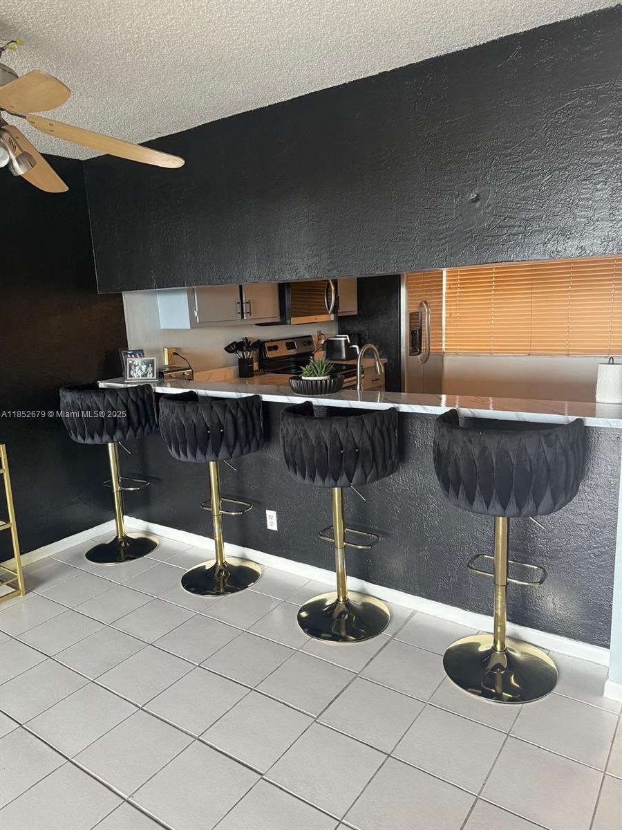 8040 Hampton Boulevard, Unit 512 North Lauderdale, FL 33068 - Photo 2 of 18 a kitchen with a sink a counter and chairs