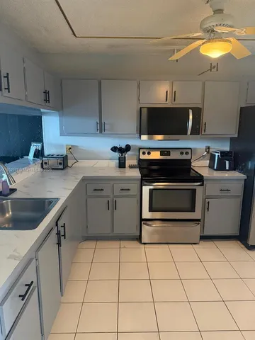 a kitchen with a sink a stove and cabinets